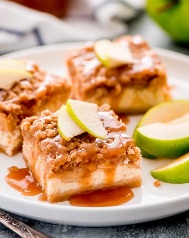 With layers of short bread crust, cheesecake, apples, streusel, and caramel drizzle, Caramel Apple Cheesecake Bars are the perfect fall dessert.