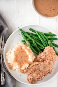 These super tender Slow Cooker Pork Chops and Gravy take just 10 minutes to prep! In four hours you'll be sitting down to a delicious home cooked meal.