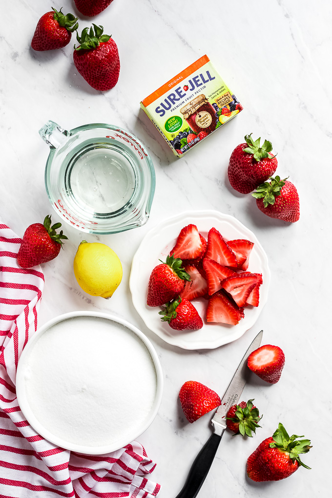 Ingredients for making freezer jam laid out on a marble surface.