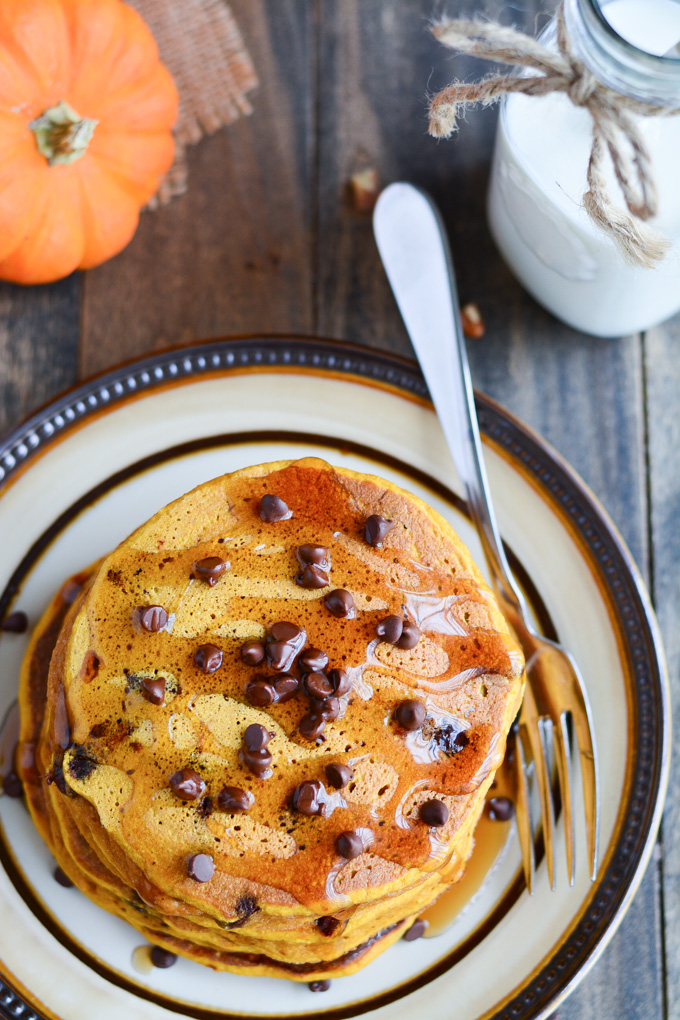 Pumpkin pancakes topped with chocolate chips and syrup.