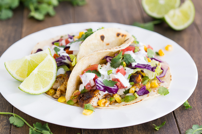 Tacos filled with spiced pan-seared tilapia, cabbage, lettuce, corn, and pico de gallo