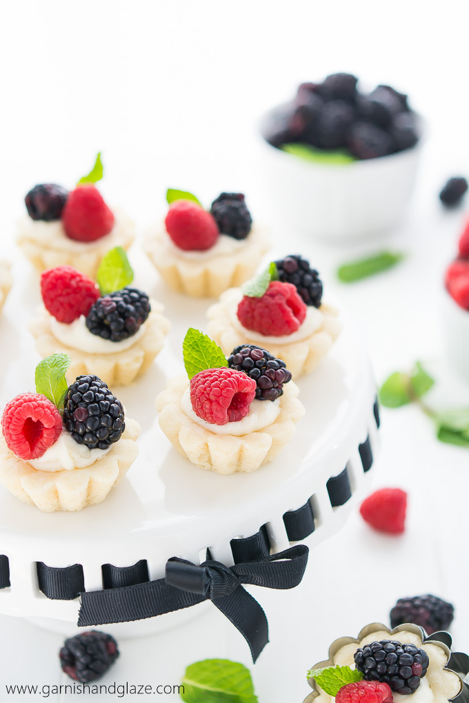 Mini Berry Tarts are perfectly portioned tarts with a tender crust, sweet creamy filling, and topped with beautiful fresh berries.