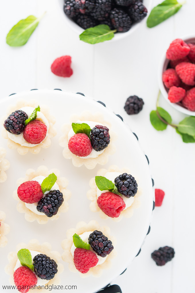 Mini Berry Tarts are perfectly portioned tarts with a tender crust, sweet creamy filling, and topped with beautiful fresh berries.
