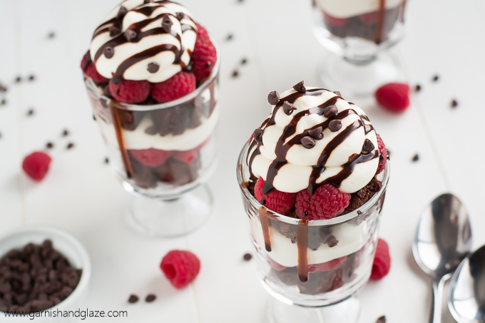 Two Raspberry Brownie Cheesecake Trifles with chocolate dripping down the sides.