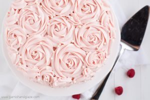 Raspberry Rose Cake is made up of two tender white cakes with sweet raspberry jam sandwiched between and then covered in rose-like swirls of silky smooth raspberry cream cheese frosting. It's the perfect cake for Valentine's Day, a bridal shower, a baby shower... or any time you need a yummy pink cake!