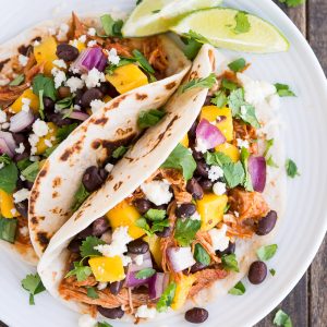 Easy slow-cooker Chipotle Pork Tacos with mango salsa on top are the perfect summer blend of sweet and spicy!