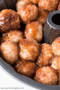 Gather round the table with your family for some Glazed Monkey Bread-- irresistible fluffy, buttery, cinnamon and sugar coated balls of bread, covered in a creamy glaze.