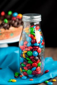 Jar of M&M's with Chew Cookie cake in background