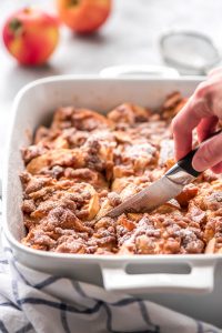 Slicing the Overnight Apple French Toast Casserole.