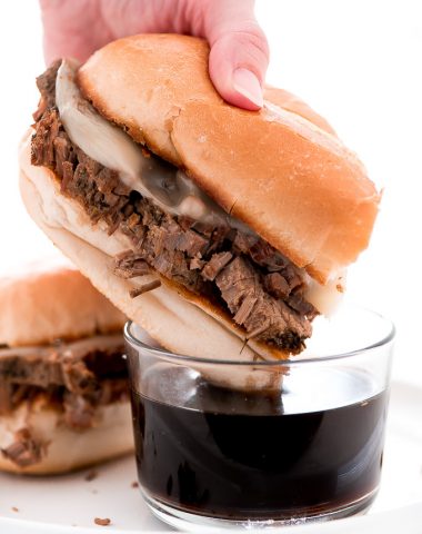 Dinner just got better with these Slow Cooker French Dip Sandwiches with hearty beef and melted provolone cheese on a toasted bun and dipped in au jus.