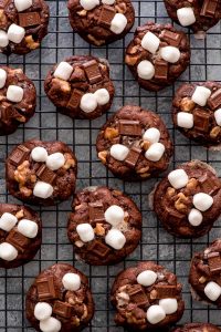 Rocky Road Cookies on cooling rack. Chocolate cookies loaded with marshmallows, chocolate chunks, and walnuts.