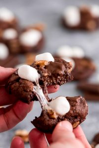 Breaking apart a rocky road cookie. Chocolate chunks are melty and marshmallows are soft and gooey.