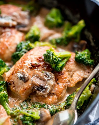 Cast iron skillet with One Skillet Chicken and Broccoli in it, covered in a garlic mushroom cream sauce.