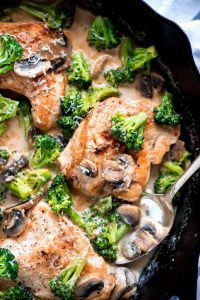 Top view of a skillet of cooked chicken and broccoli.