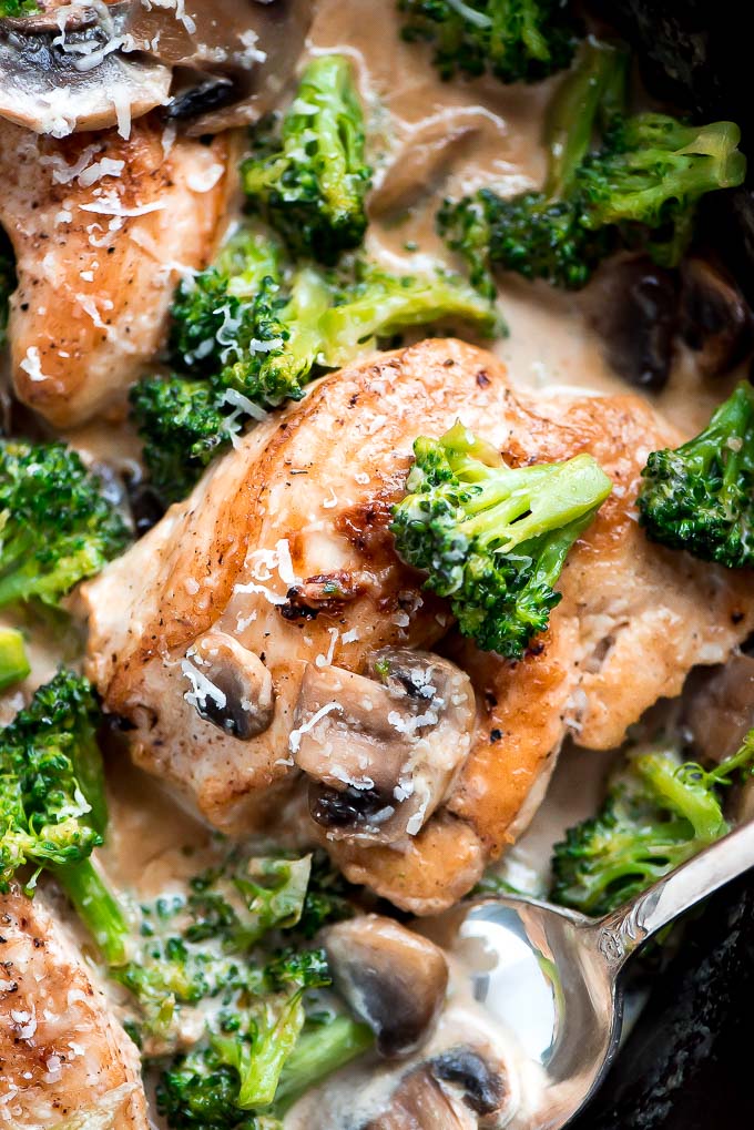 Close up birds eye view of a skillet of cooked chicken and broccoli.