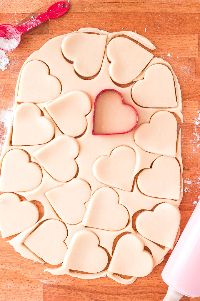 Sugar Cookie dough cut out with a a heart shaped cookie cutter.