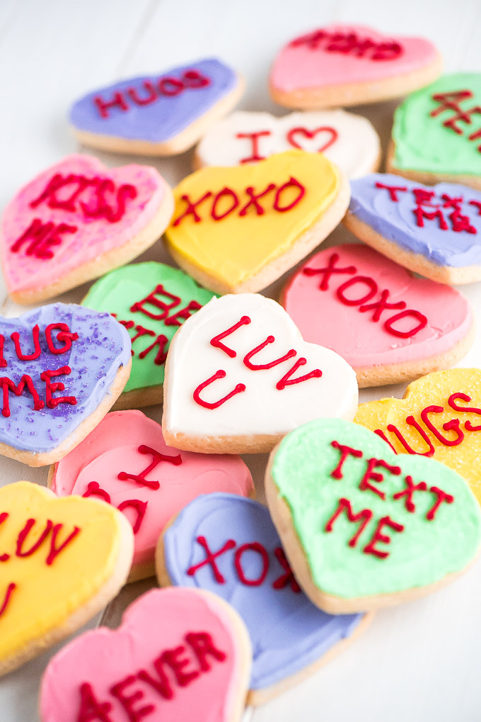 A pile of Conversation Heart Sugar Cookies with messages like "Luv U" and "text me".