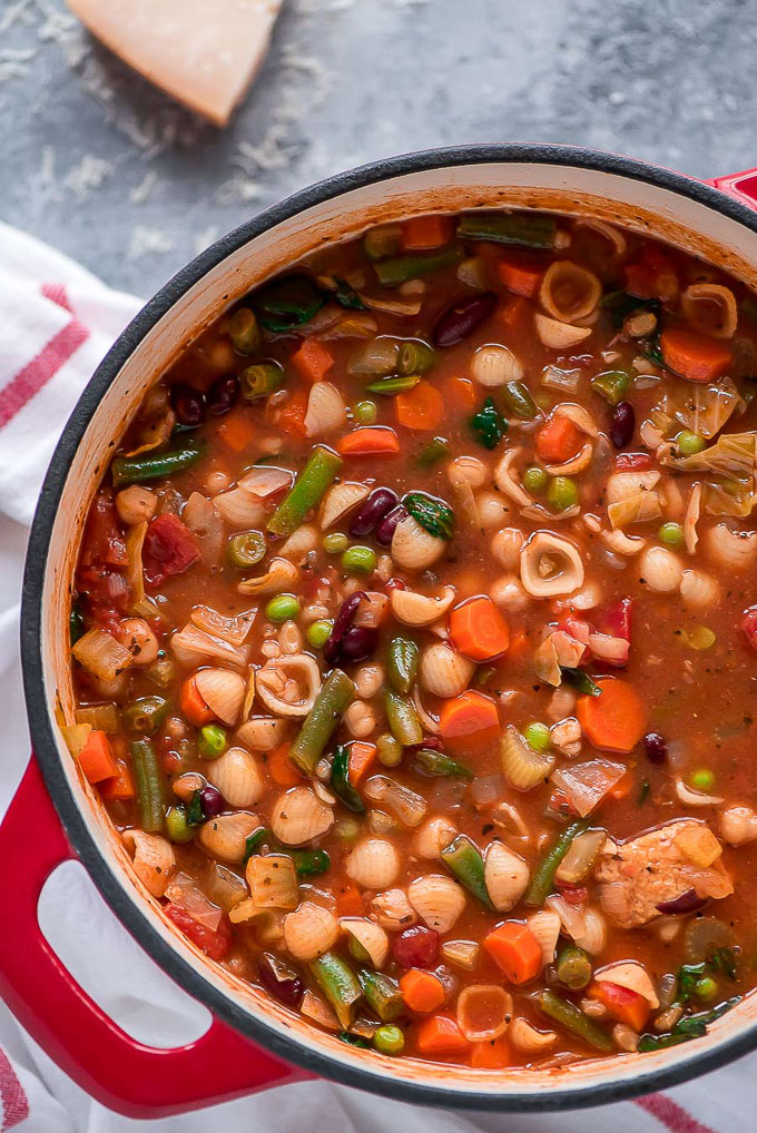 Large stock pot of Minestrone Soup made up of a variety of vegetables, beans, and pasta shells.