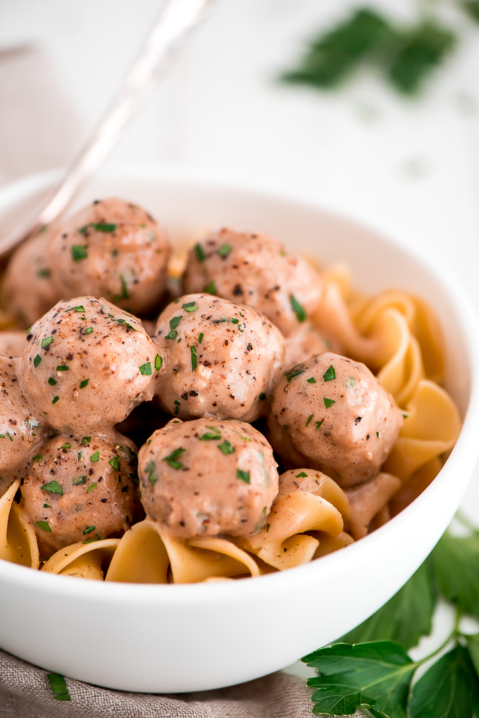 Close up of a bowl of Swedish Meatballs on top of egg noodles.