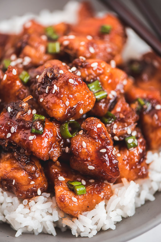 Close up of Instant Pot Honey Garlic Chicken over white rice and topped with green onions and sesame seeds.