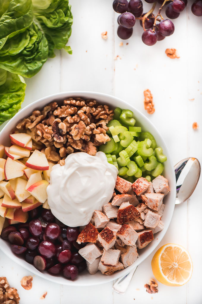 Chicken Waldorf Salad in a bowl showing all ingredients- chicken, walnuts, celery, apples, grapes, and dressing.