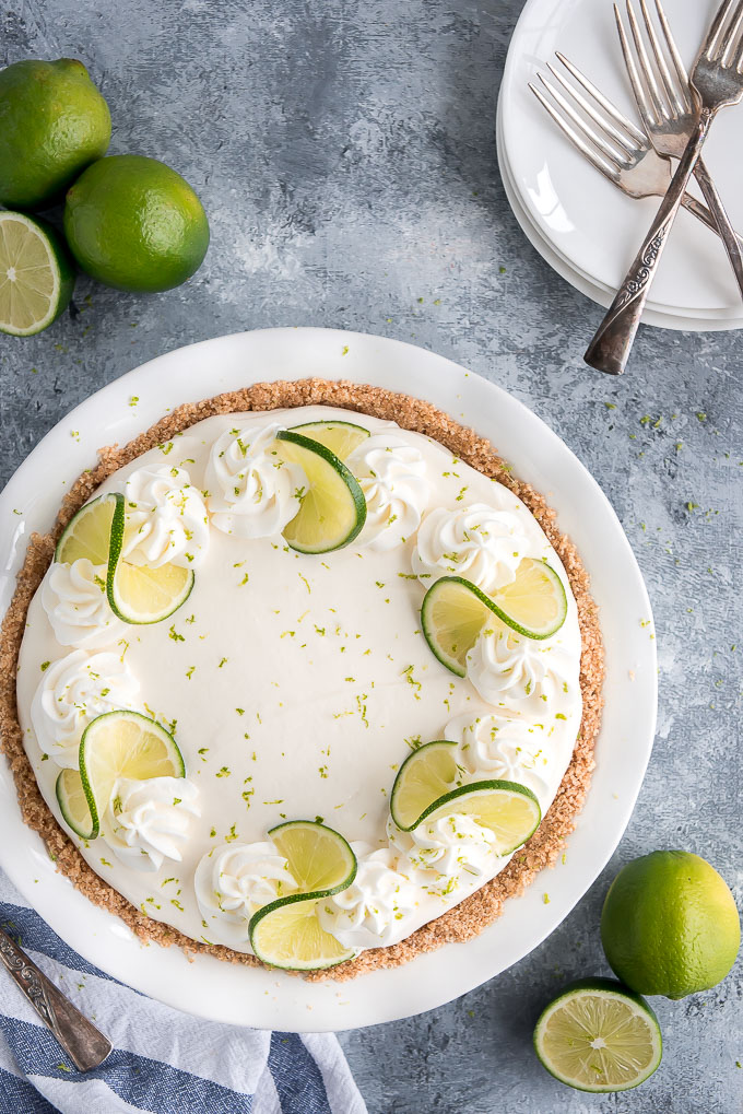 Top view of No Bake Key Lime Pie topped with whipped cream, twisted time slices, and lime zest.