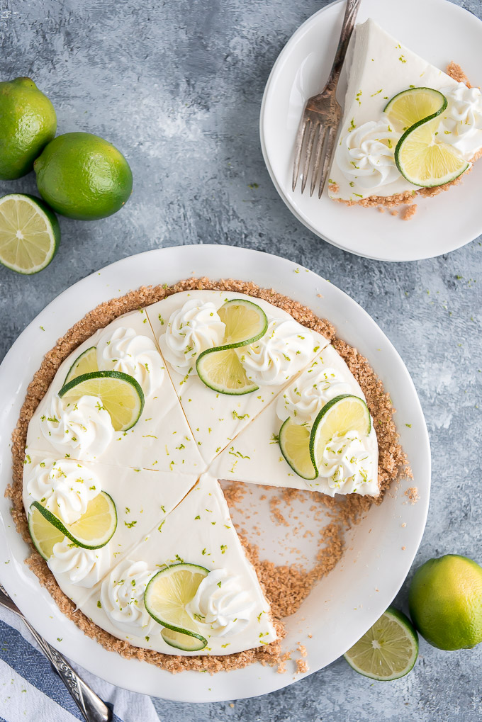 Top view of the BEST Key Lime Pie sliced into wedges and a slice taken out on a plate ready to serve.