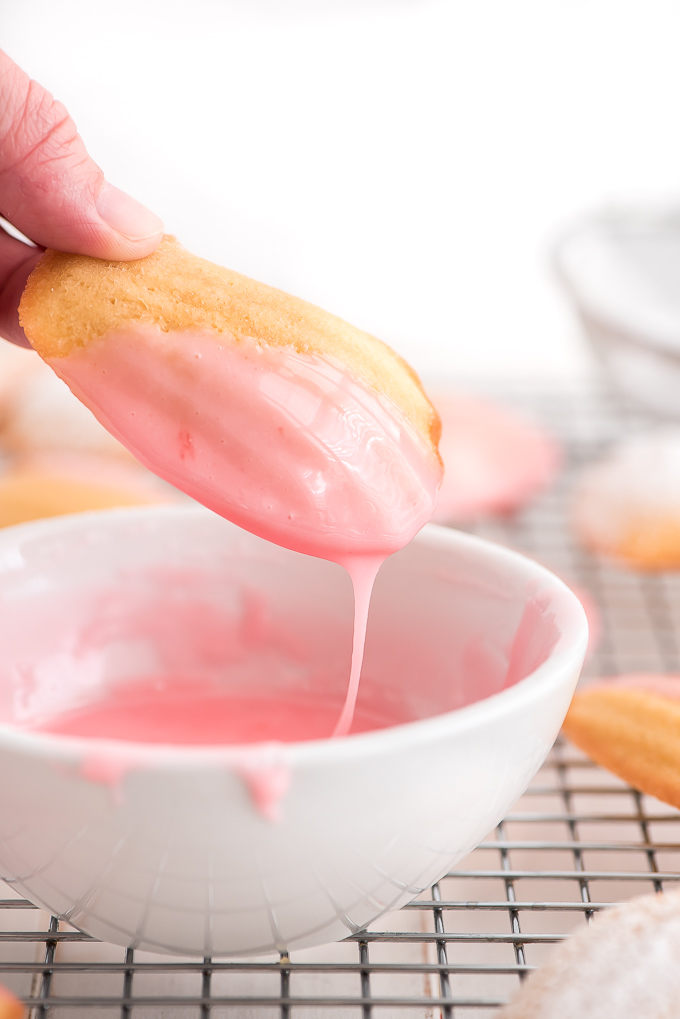 Dipping French Madeleine in pink glaze.