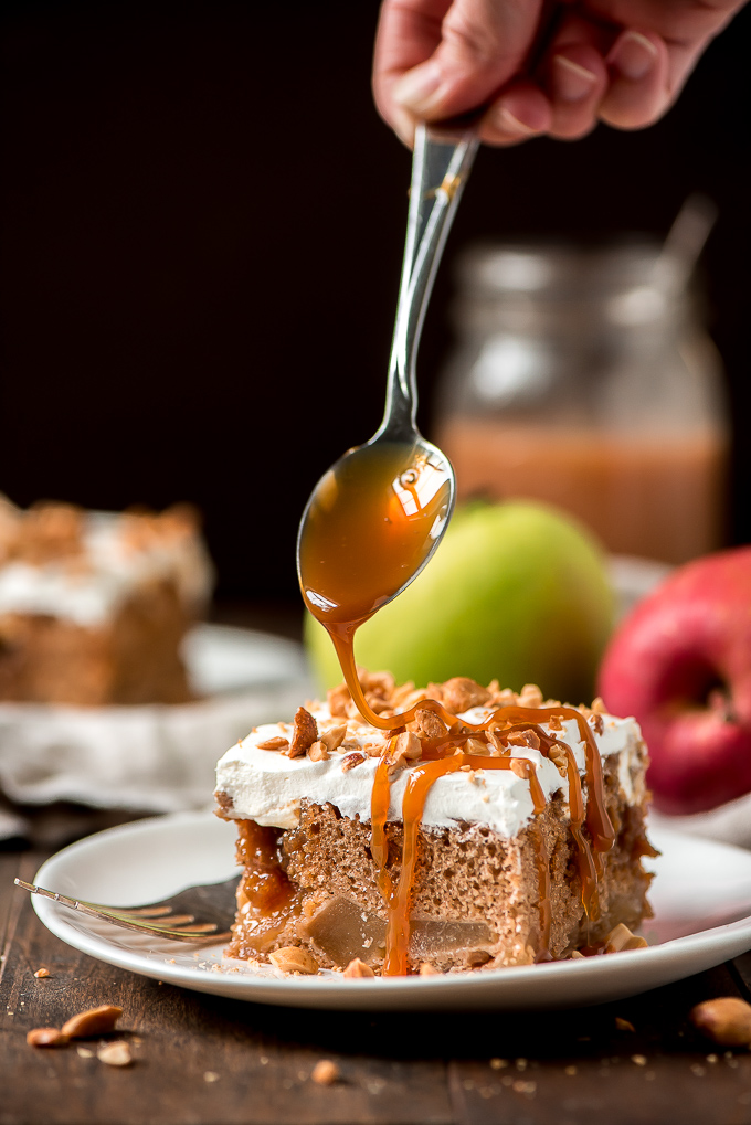 Drizzling caramel sauce on top of a piece of Caramel Apple Poke Cake.