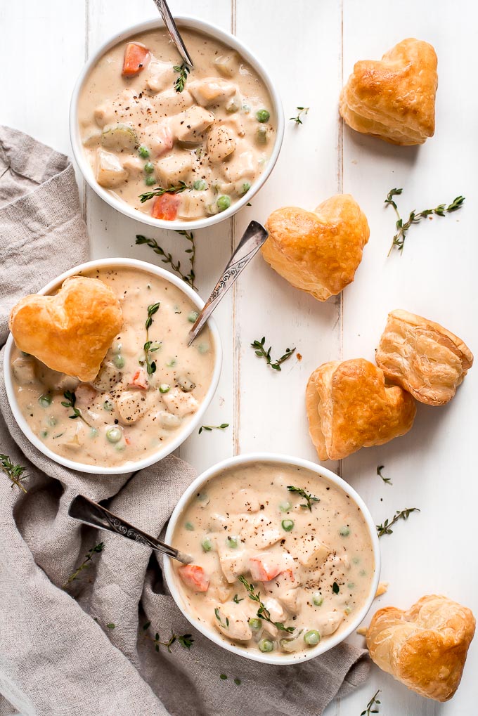 Three bowls of easy Chicken Pot Pie Soup with puff pastry hearts on the side.
