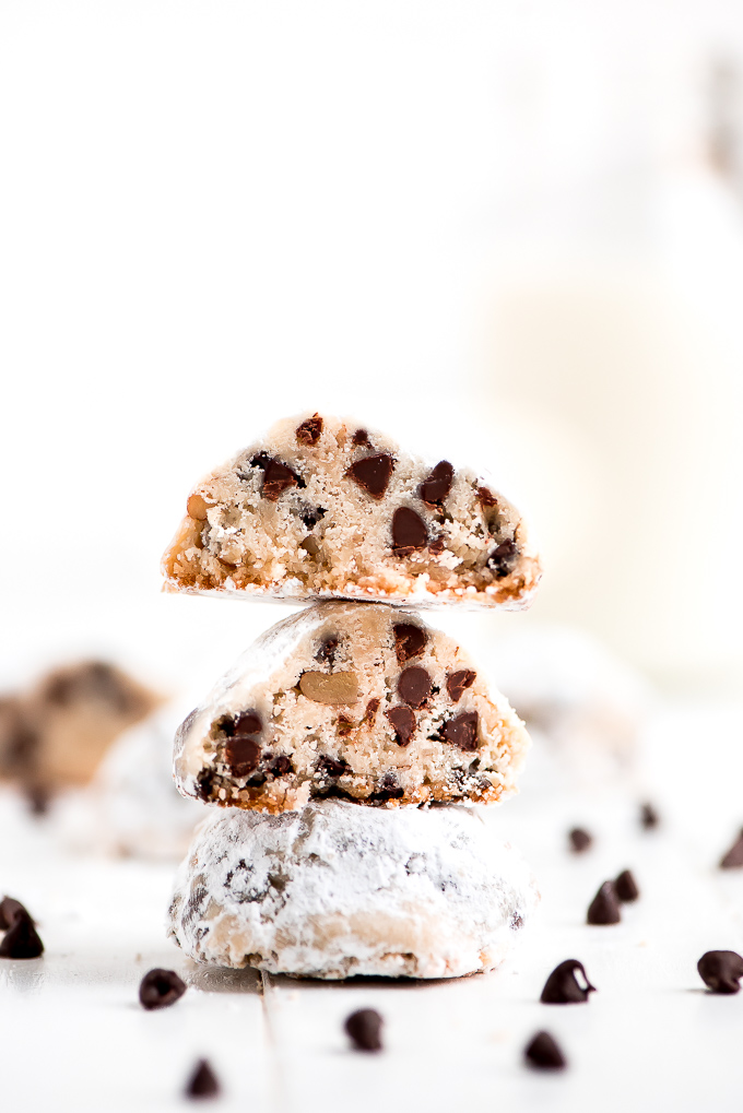 Chocolate Chip Snowball Cookies cut in half and stacked on top of each other showing the mini chocolate chips inside.