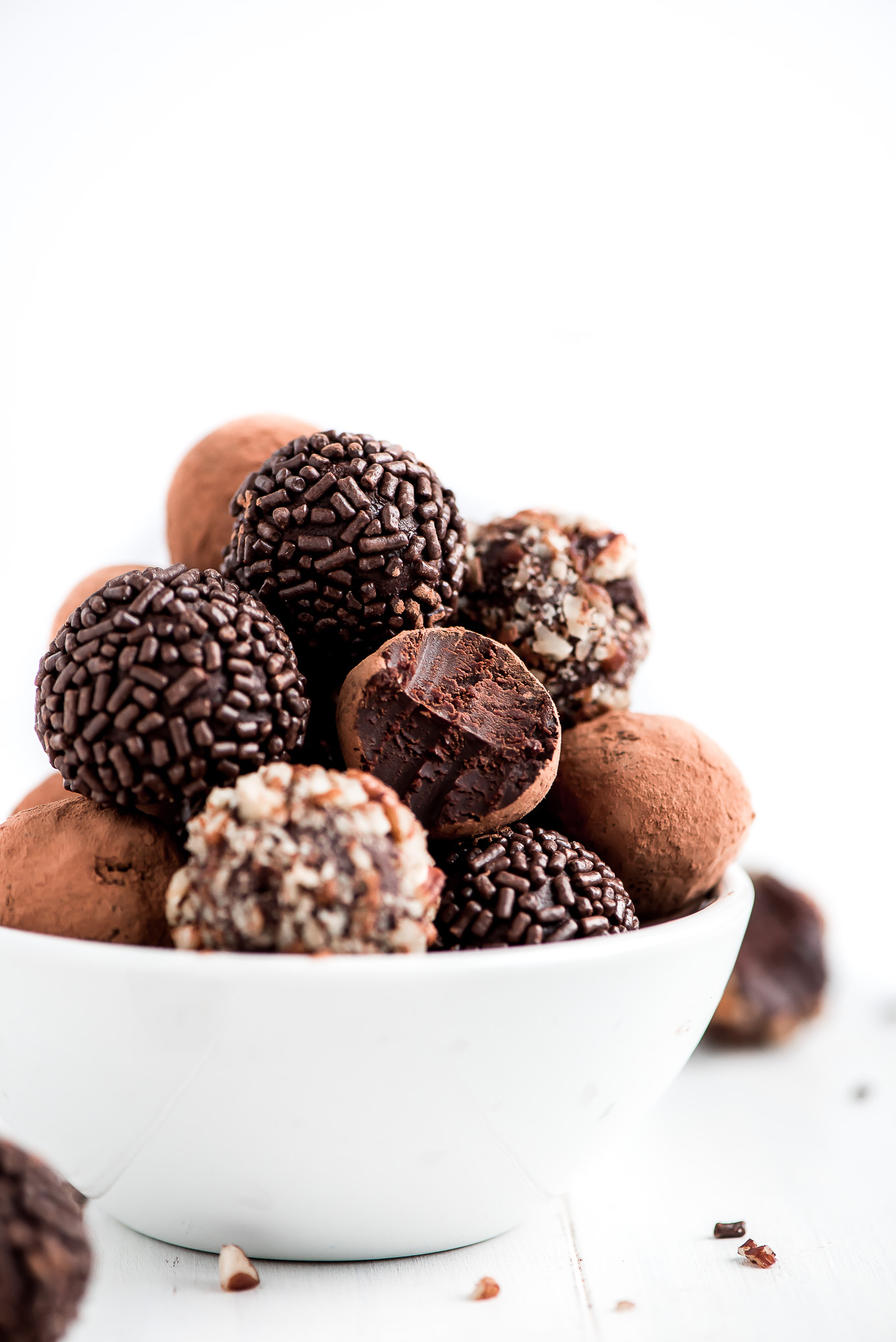 Bowl of 4-Ingredient Chocolate Truffles. Rolled in chocolate sprinkles, pecans, or cocoa powder.