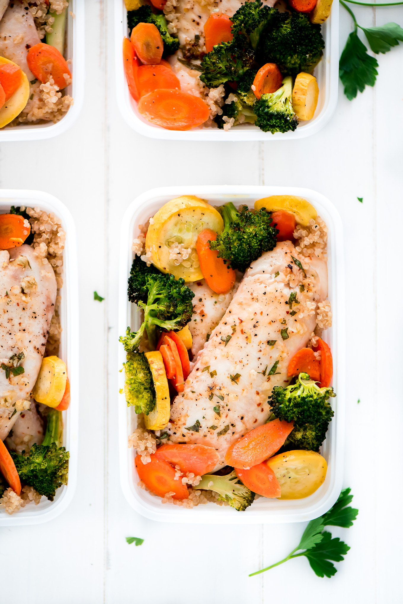 Sheet Pan Baked Tilapia with Roasted Vegetables in a meal prep container.