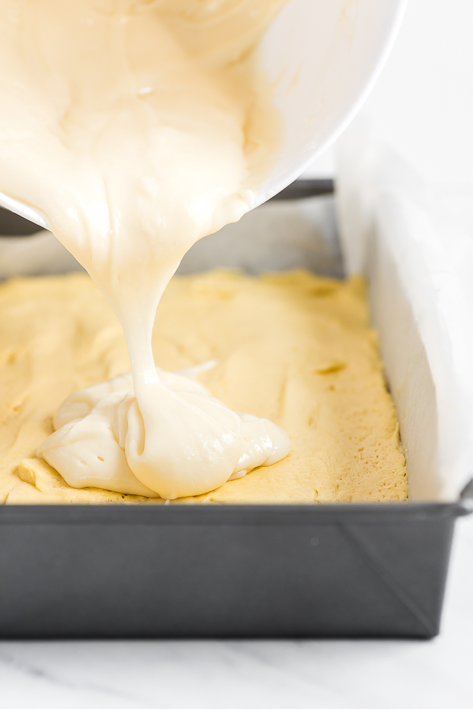 Pouring the gooey layer on top of the cake batter layer.