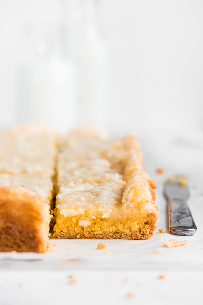 Side view of a piece of Gooey Butter Cake showing the cake layer, gooey layer, and flaky top.