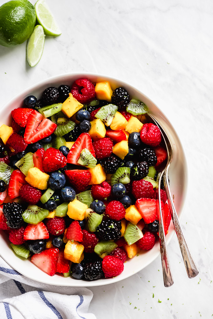 Berries, kiwi, and mango mixed together in a fruit salad.