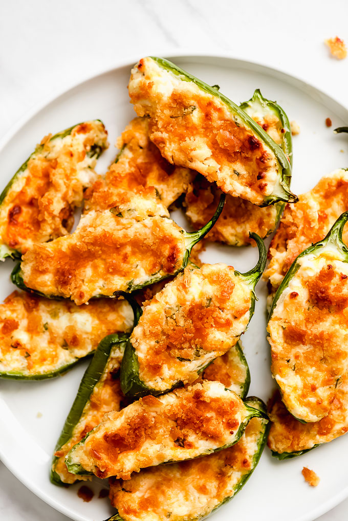 Jalapeño Poppers stacked on top of each other on a plate.