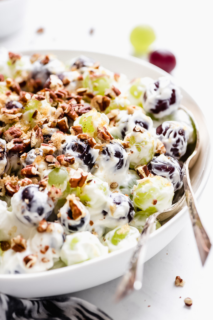 Close up shot of Creamy Grape Salad in a bowl with two spoon in the bowl.