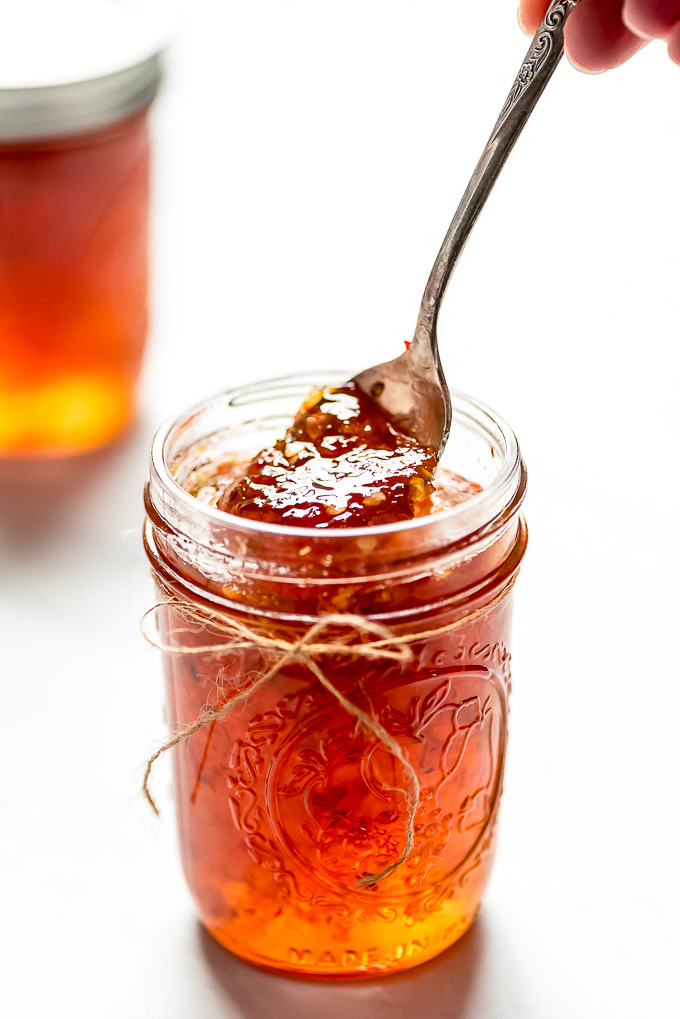 Lifting a spoonful of Hot Pepper Jelly out of a jar.
