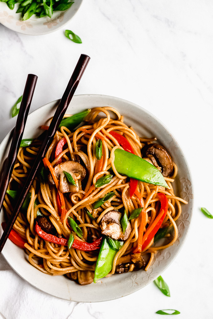 Top view of a bowl of Lo Mein with chop sticks resting on the side of bowl.