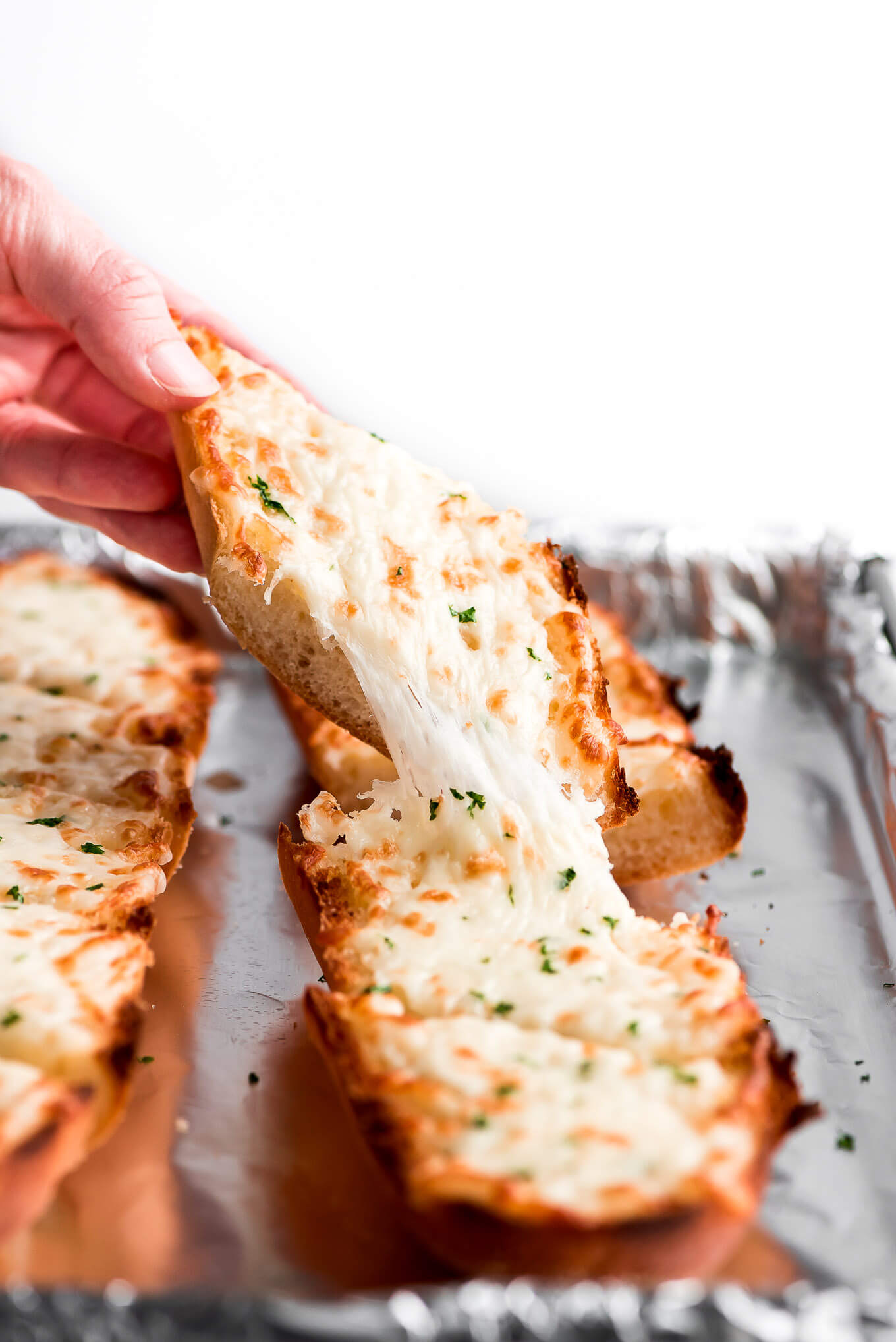 Close up shot of a cheese pull of garlic bread.