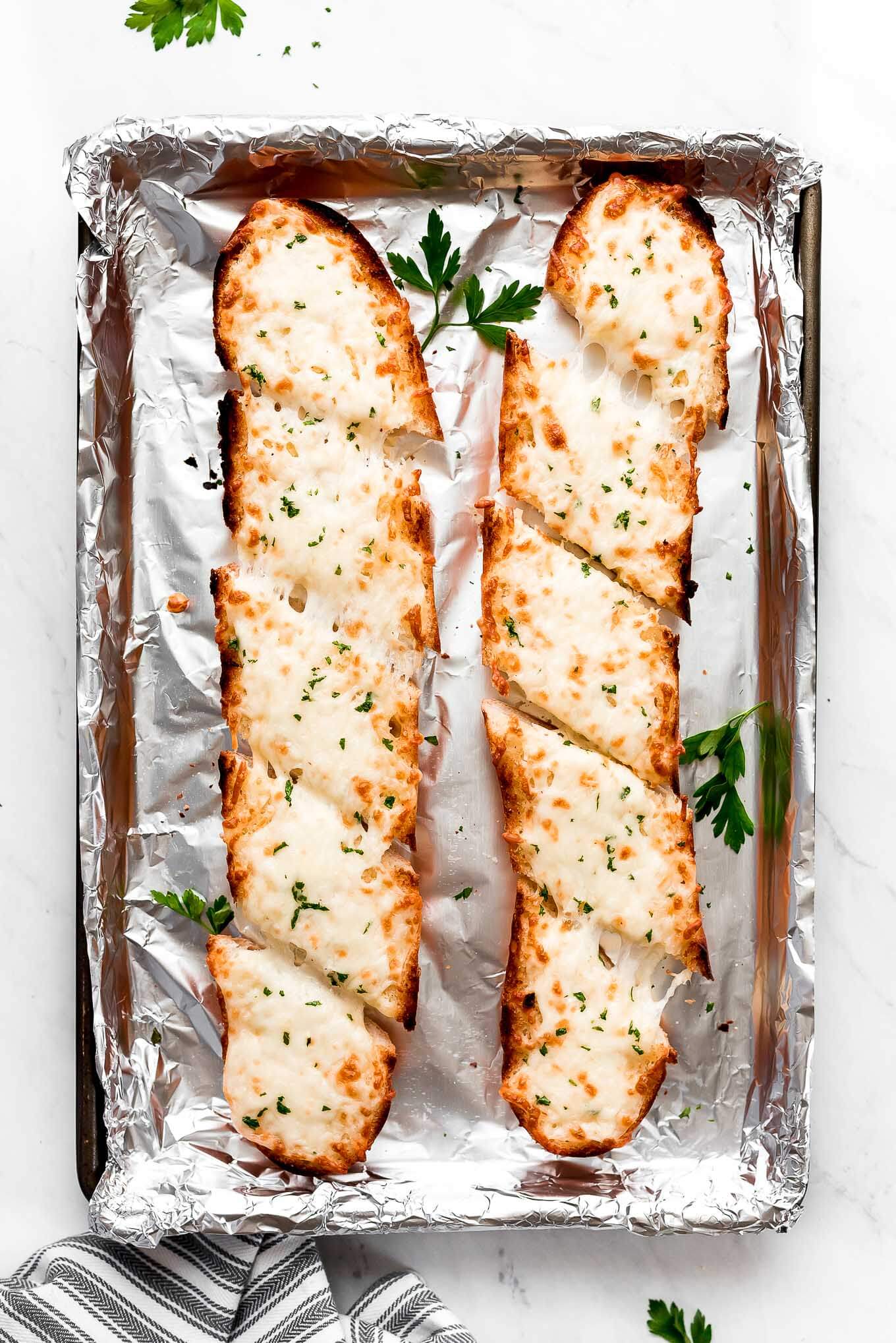 Two loafs of cheesy garlic bread baked until golden.