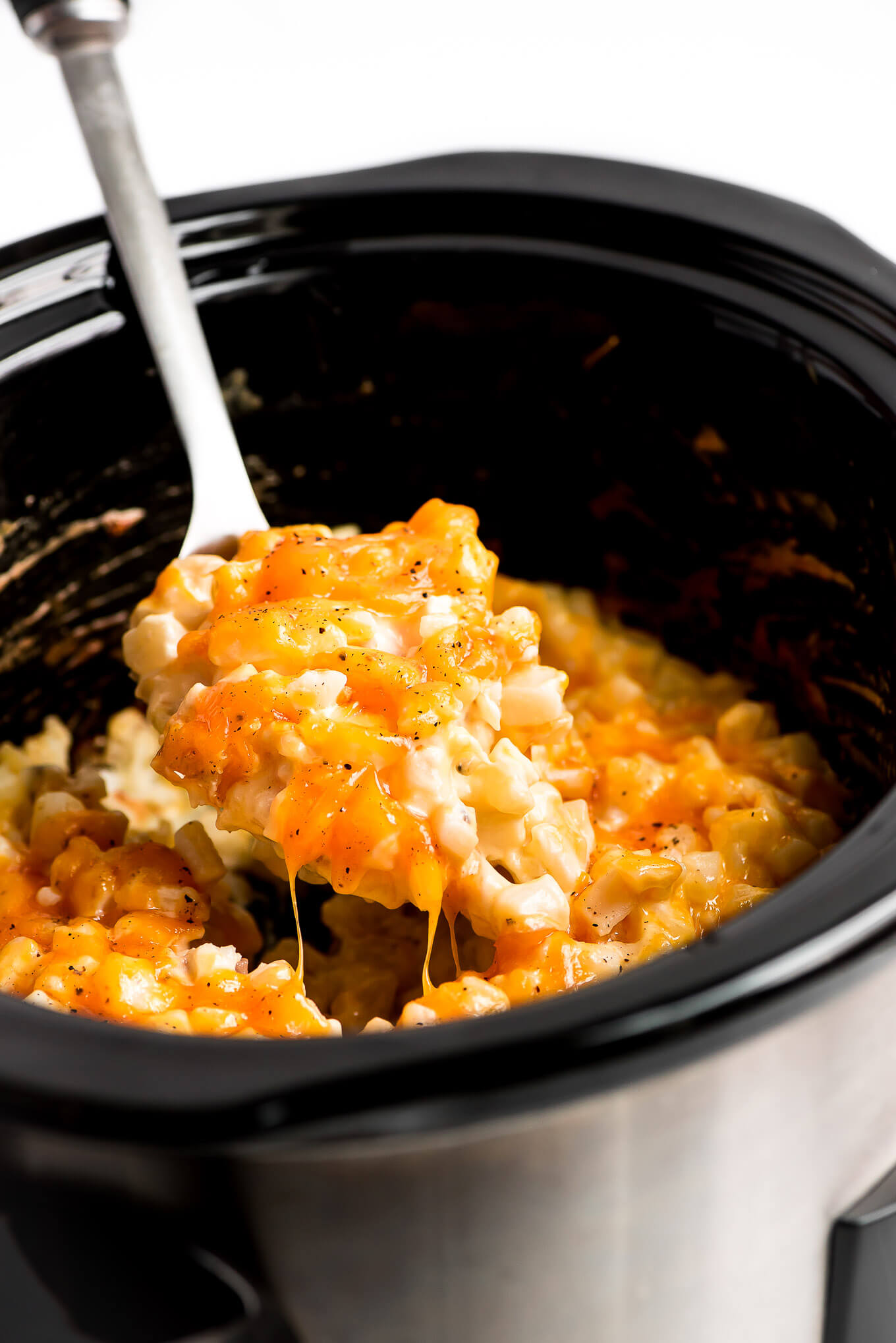 Lifing out a spoonful of Slow Cooker Cheesy Potatoes.