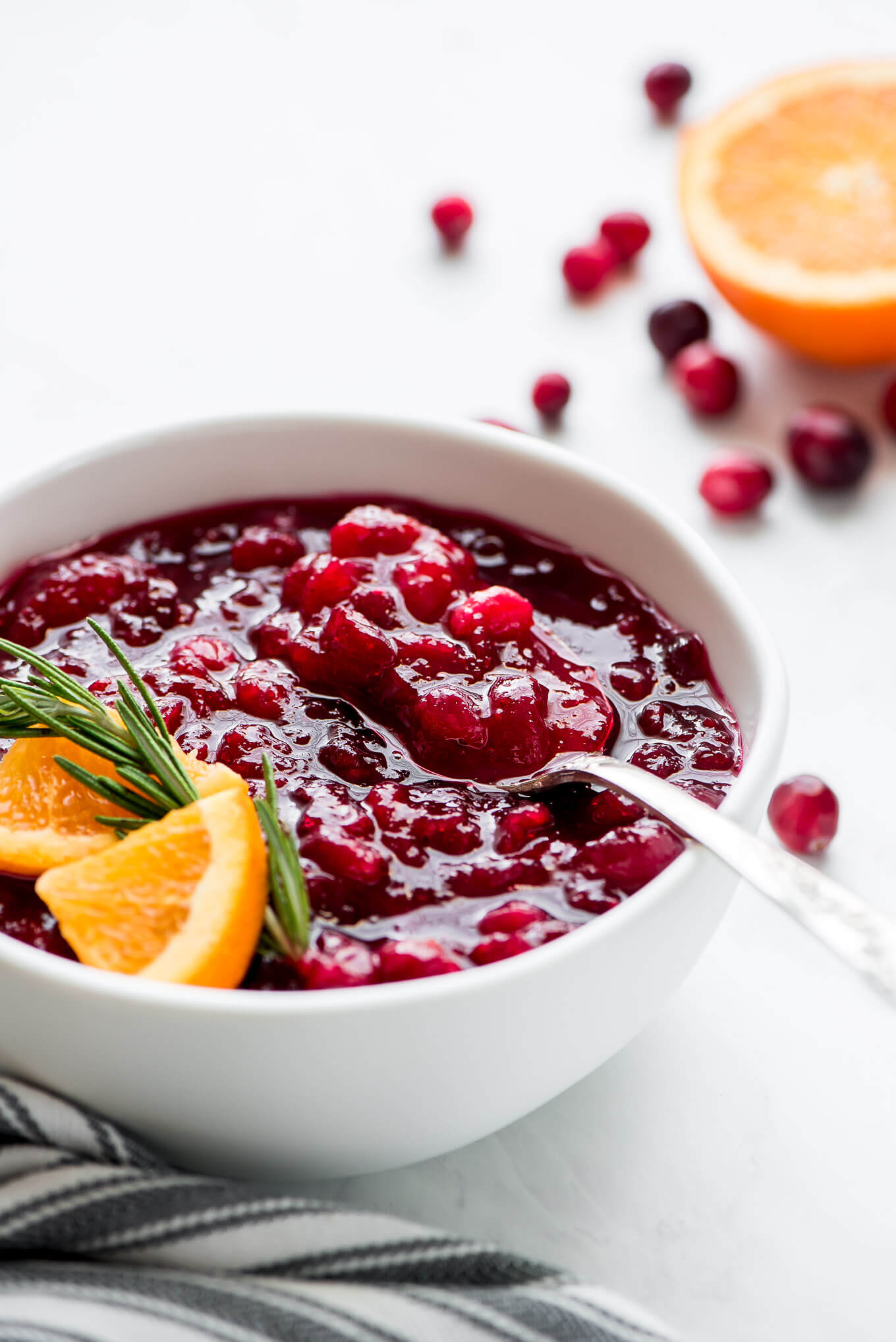 A spoon scooping up some cranberry sauce from a bowl.