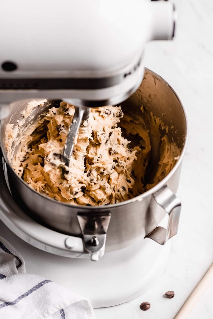 Chocolate Chip cookie dough in a white electric Kitchen Aid mixer.