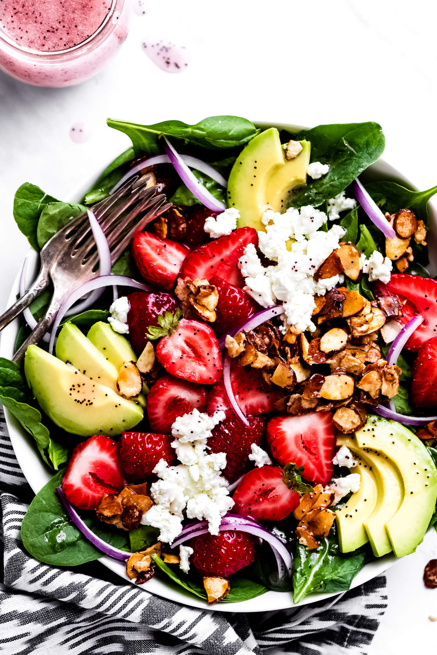 Strawberry Salad with avocado, candied almonds, goat cheese, red onion, and baby spinach.