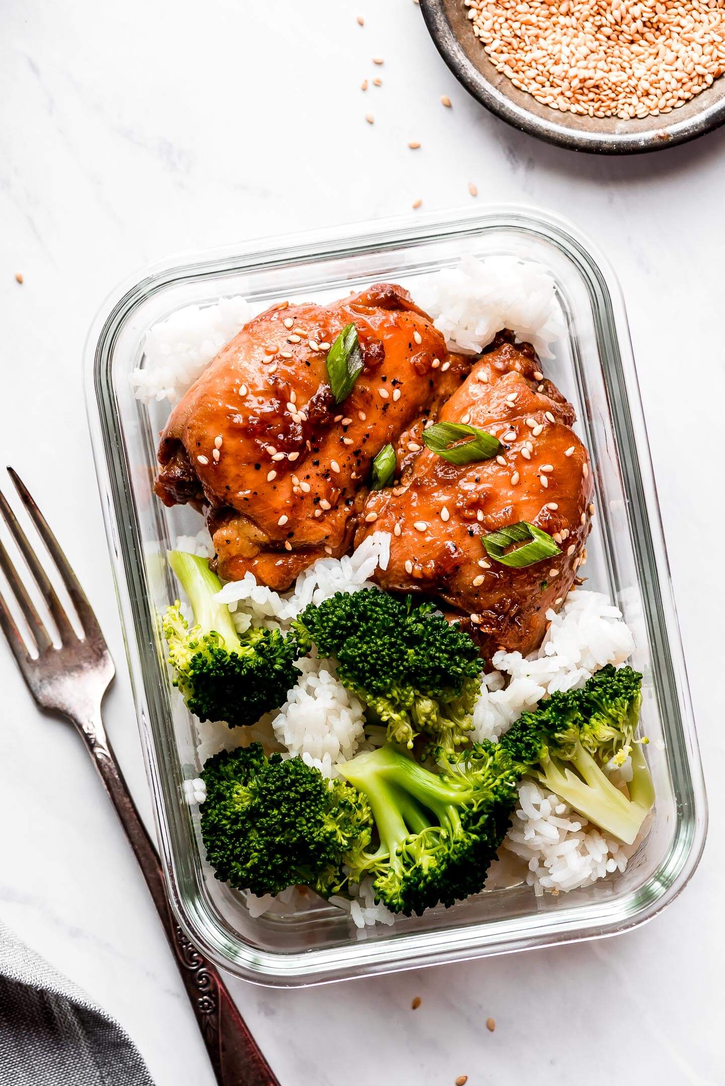 A rectangle meal prep container with teriyaki chicken white rice, and broccoli.