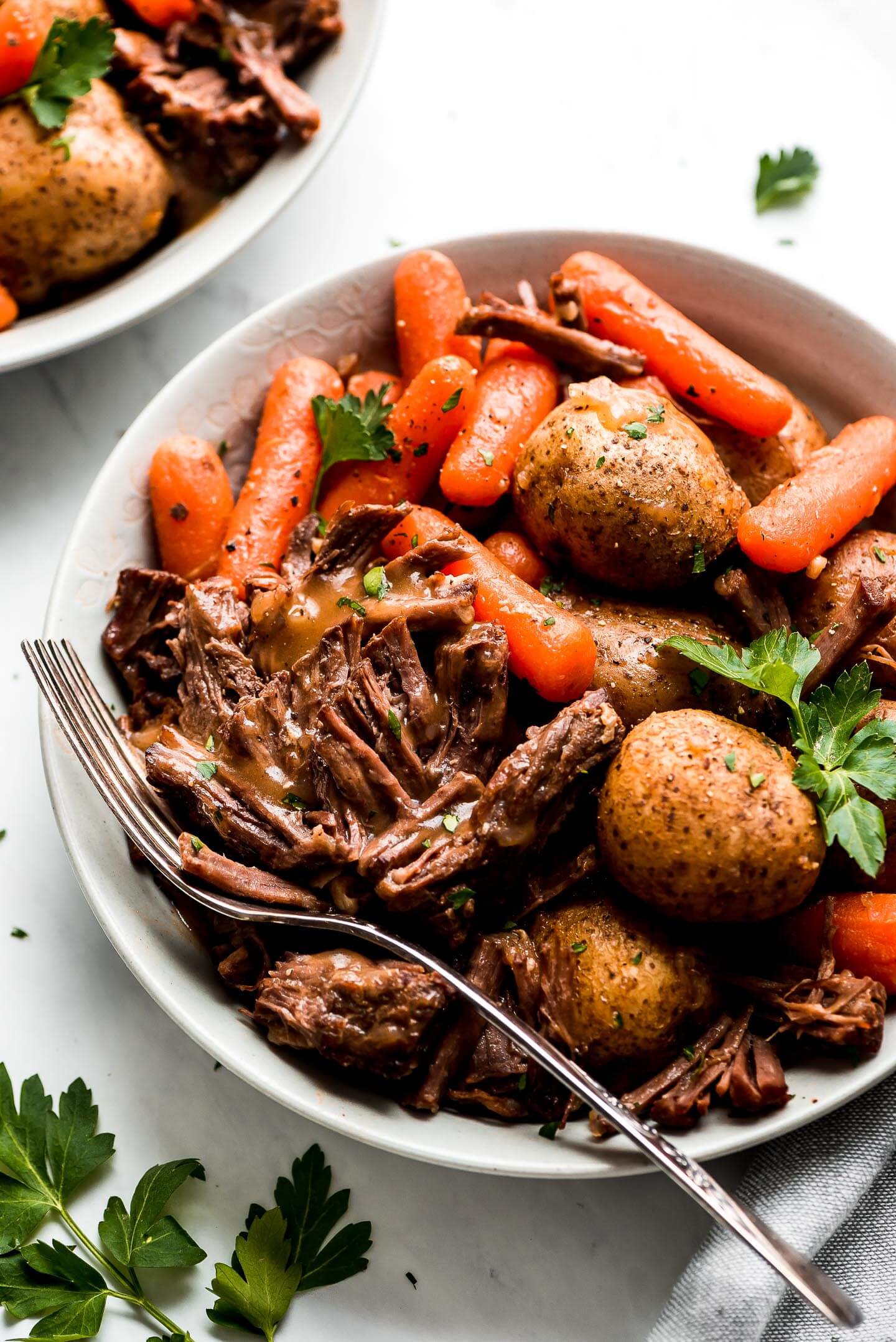 Instant Pot Pot Roast in a bowl with carrots, and baby yukon potatoes.