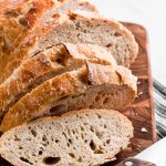No Knead Bread sliced on a cutting board.