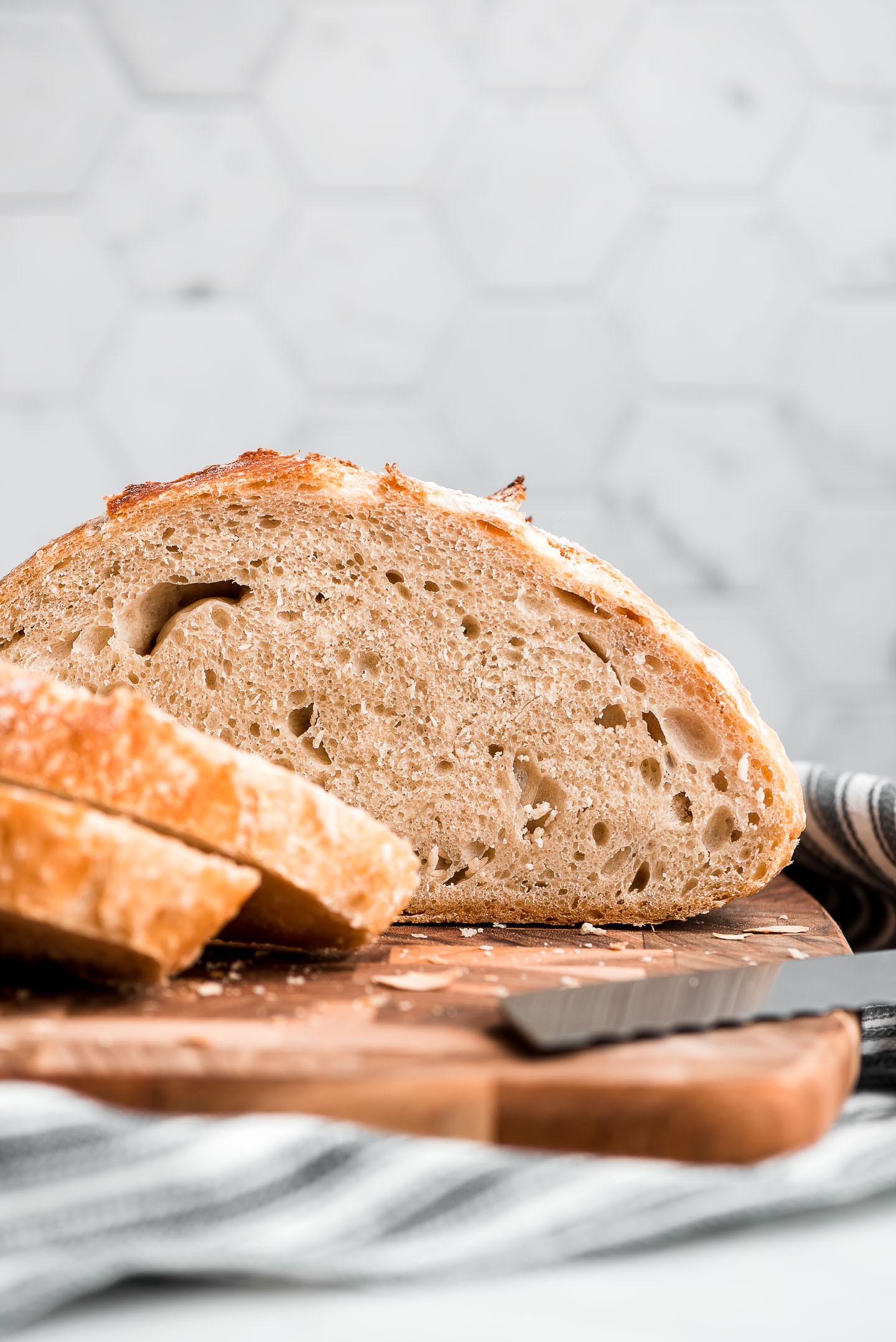 Half a loaf of No Knead artisan bread sitting on a cutting board.